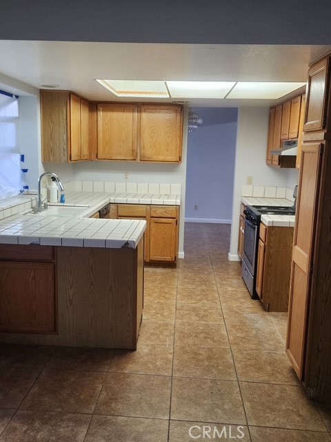 438 Sherwood Place Tehachapi, CA 93561 - Photo 2 of 5 a kitchen with a sink a stove top oven and cabinetry