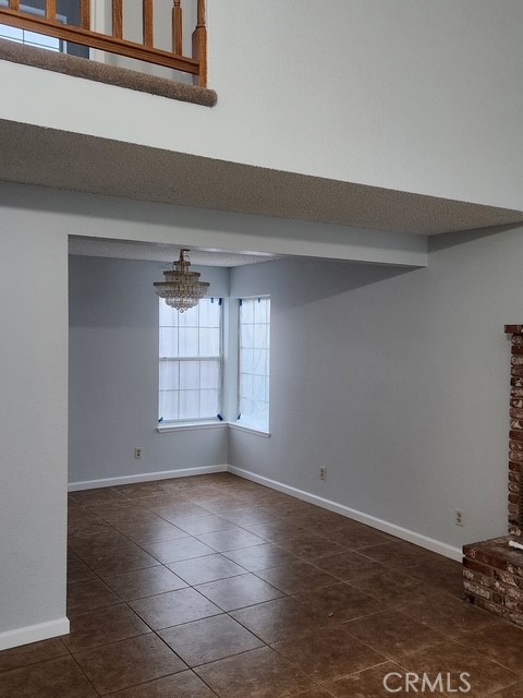 438 Sherwood Place Tehachapi, CA 93561 - Photo 3 of 5 an empty room with wooden floor and windows