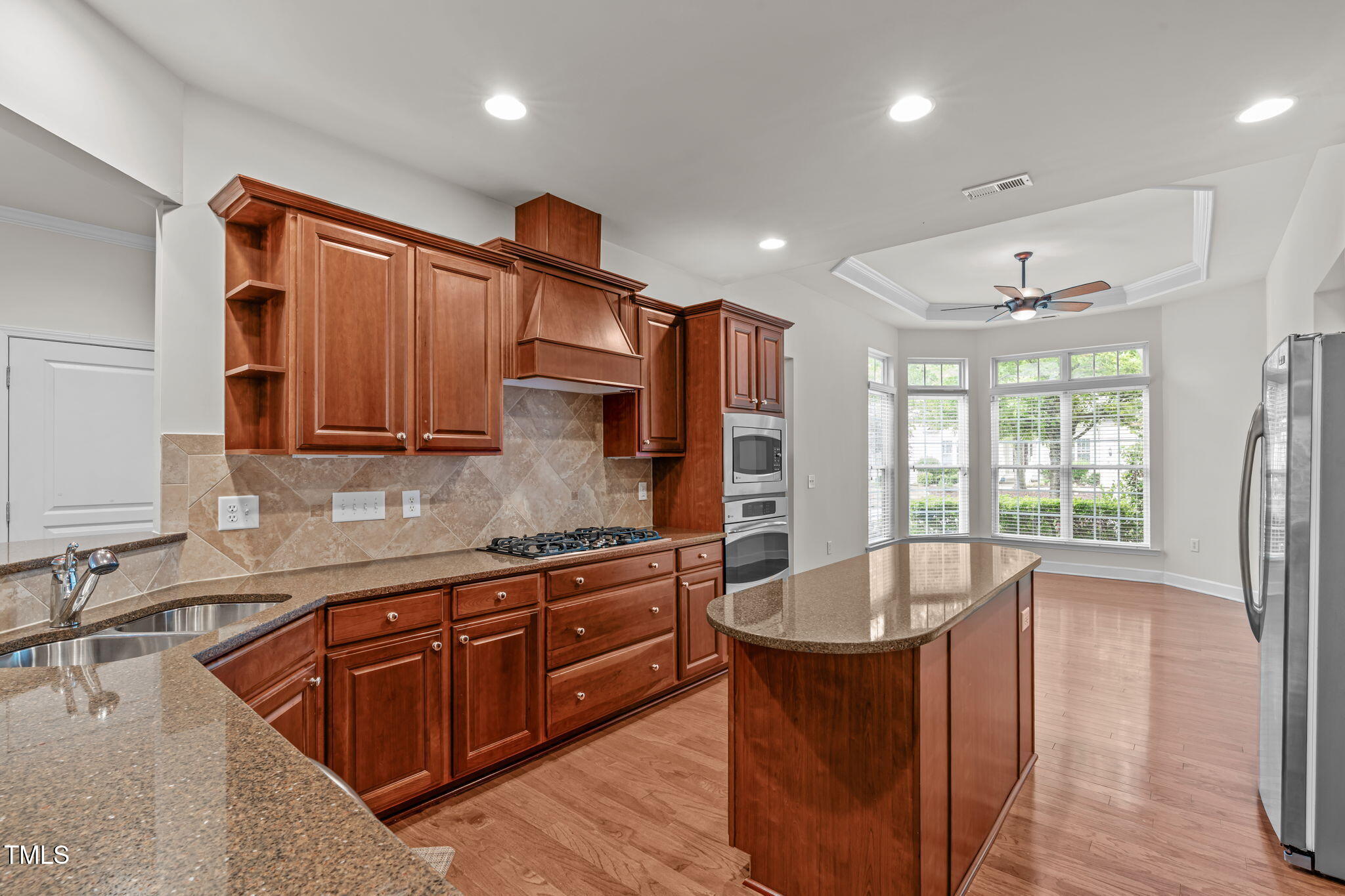 208 Beckingham Loop Cary, NC 27519 - Photo 15 of 47 a kitchen with stainless steel appliances granite countertop a sink a stove and a wooden floors