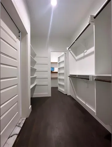 a view of walk in closet with empty racks