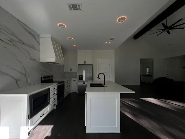 a kitchen with a sink appliances and cabinets