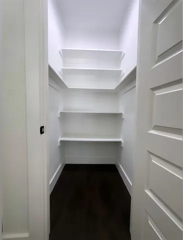 a view of walk in closet with empty racks
