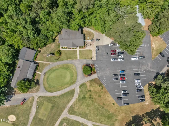 an aerial view of a house with swimming pool and large trees
