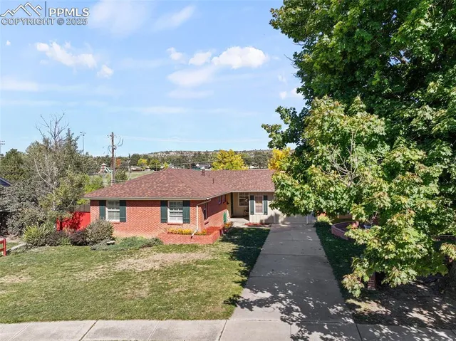 a front view of a house with a yard and trees