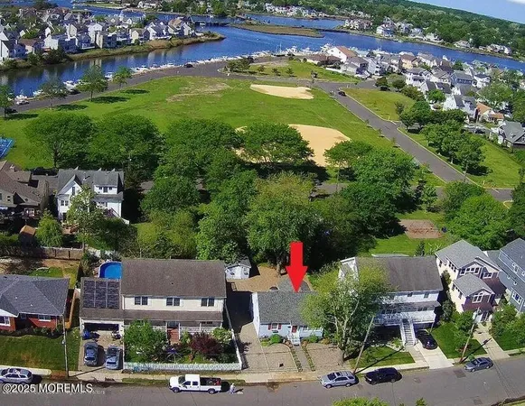an aerial view of a houses with a garden and lake view