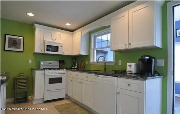 a kitchen with granite countertop a sink a stove and cabinets