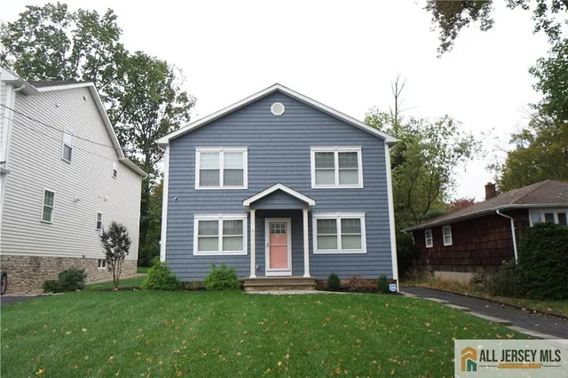 a front view of a house with a garden and yard