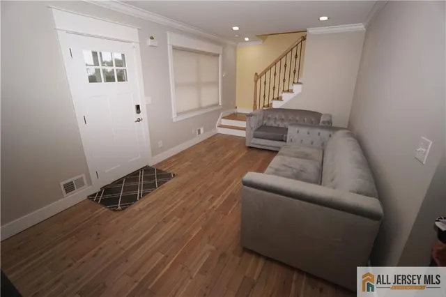 a living room with furniture and a wooden floor