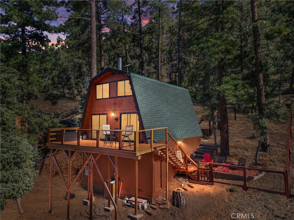 a view of a tall white house with a small yard and large tree