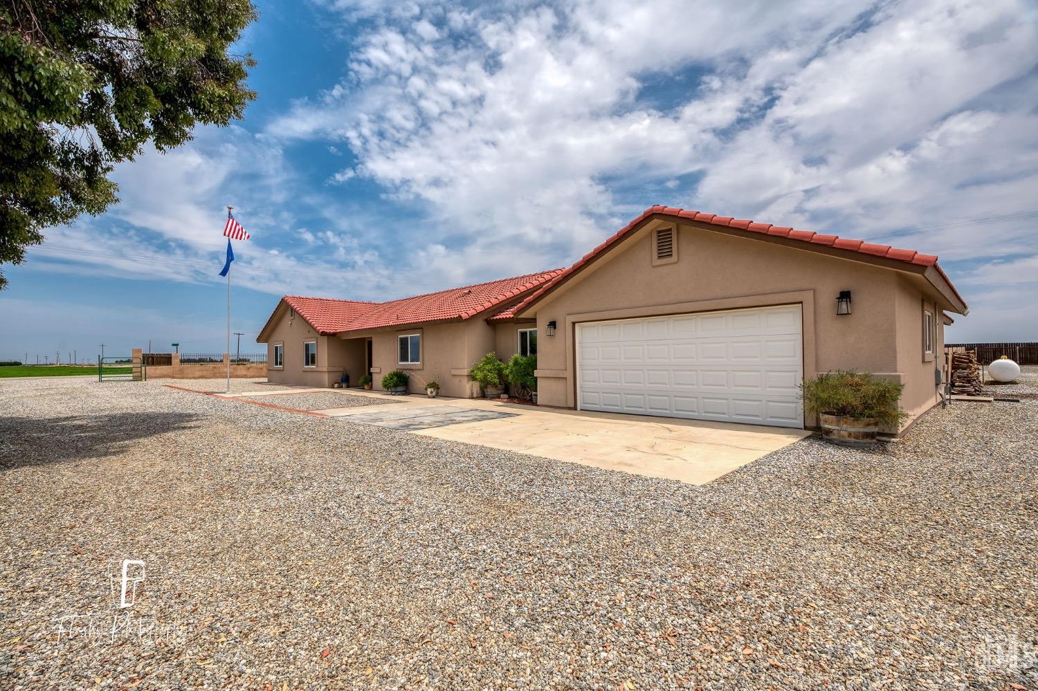 Undisclosed Address Buttonwillow, CA 93206 - Photo 5 of 65 a front view of a house with a yard and garage