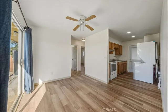 a view of a kitchen with a sink refrigerator and wooden floor
