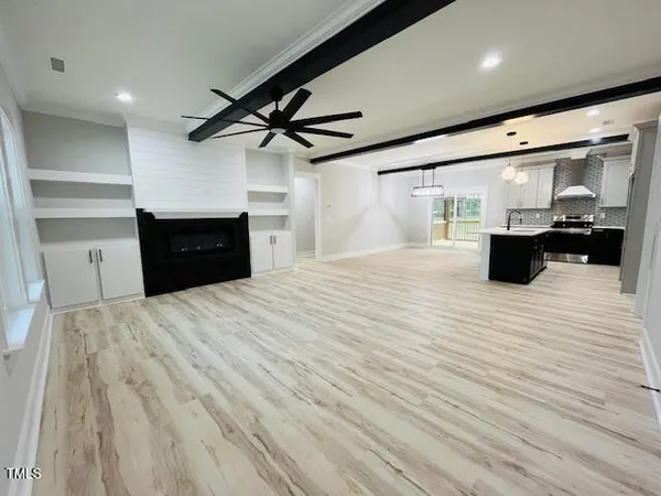a kitchen with stainless steel appliances wooden floor and chandelier