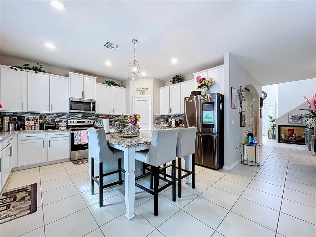 472 6th Avenue Northwest Ruskin, FL 33570 - Photo 22 of 96 a kitchen with stainless steel appliances kitchen island granite countertop a refrigerator and cabinets