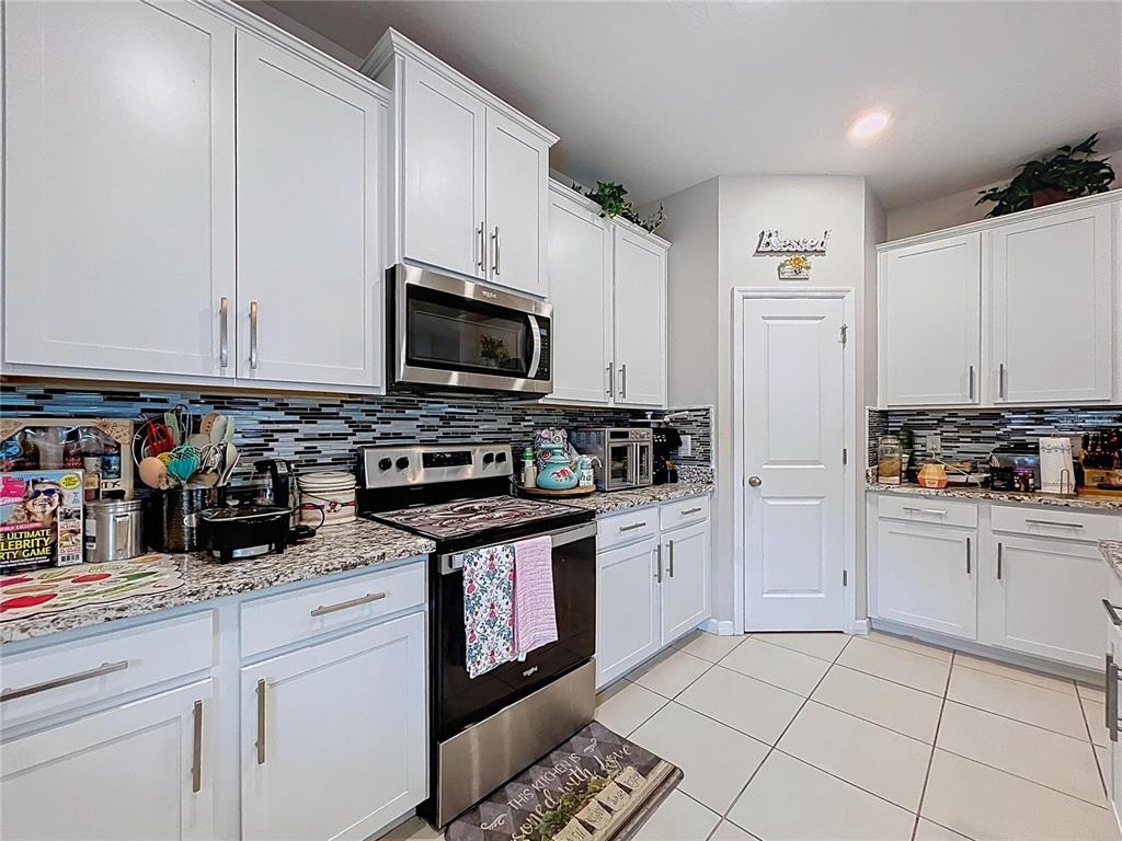 472 6th Avenue Northwest Ruskin, FL 33570 - Photo 26 of 96 a kitchen with stainless steel appliances granite countertop a stove a sink and a white cabinets