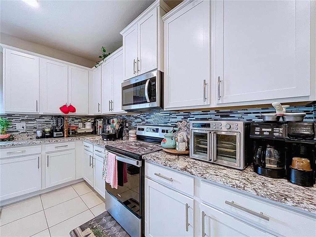 472 6th Avenue Northwest Ruskin, FL 33570 - Photo 27 of 96 a kitchen with granite countertop cabinets stainless steel appliances and a counter space