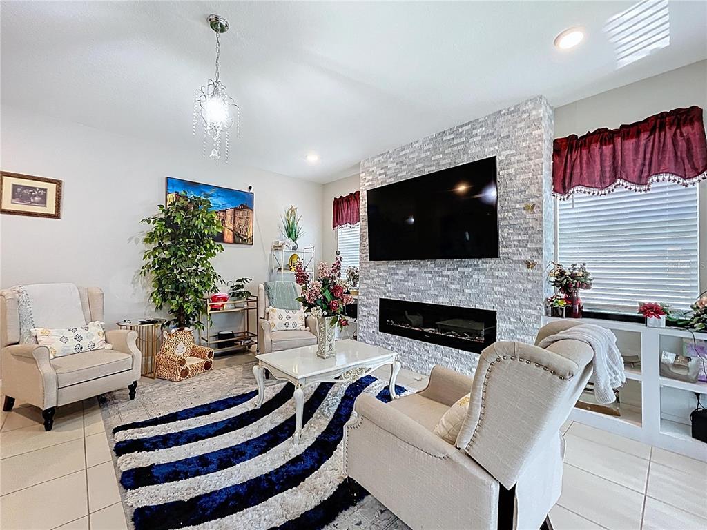 472 6th Avenue Northwest Ruskin, FL 33570 - Photo 30 of 96 a living room with furniture a flat screen tv and a fireplace