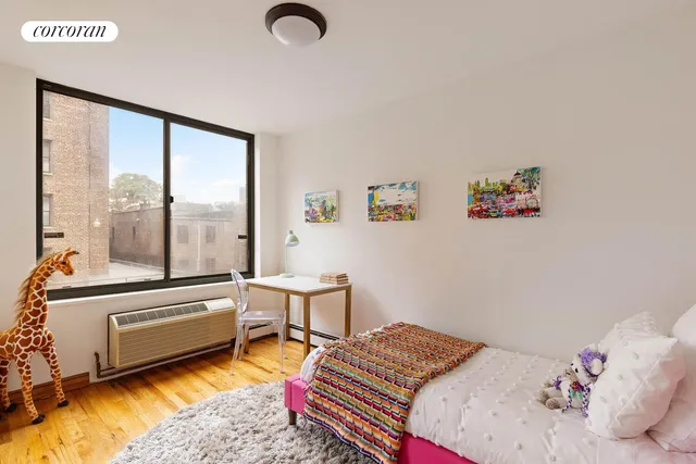 a bedroom with a bed and a large window