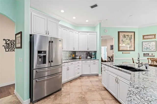a kitchen with stainless steel appliances granite countertop a refrigerator sink and stove