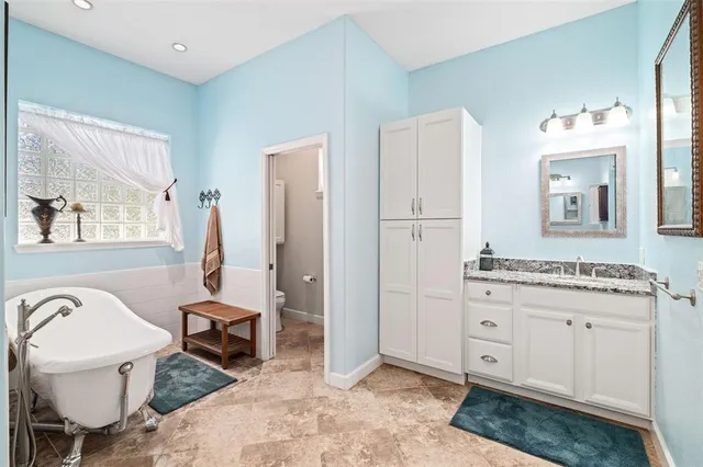 a spacious bathroom with a granite countertop sink and a mirror