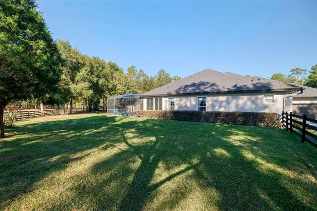 a view of a house with a big yard and a large tree