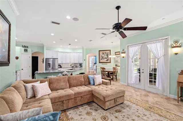 a living room with furniture kitchen view and a chandelier