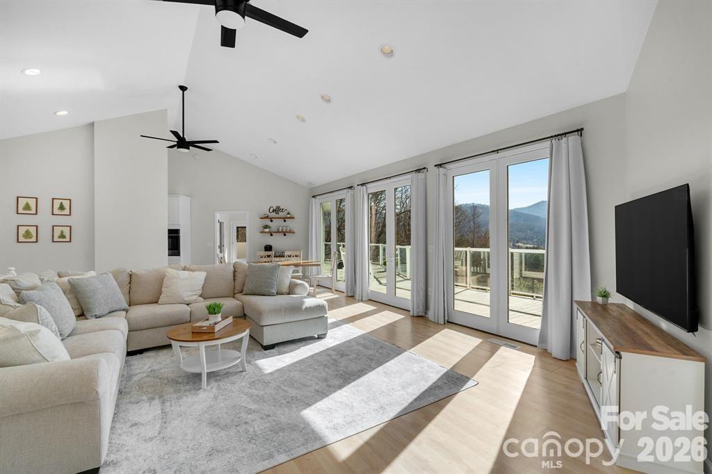 56 Great Horned Owl Road Candler, NC 28715 - Photo 5 of 32 a living room with furniture a flat screen tv and a floor to ceiling window