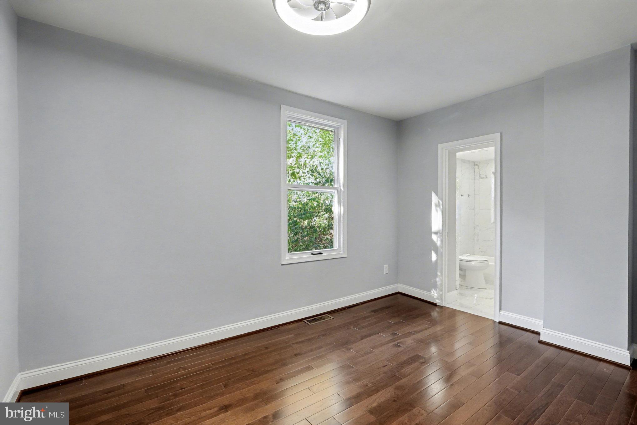 5406 Taylor Road Hyattsville, MD 20781 - Photo 11 of 26 an empty room with wooden floor and windows