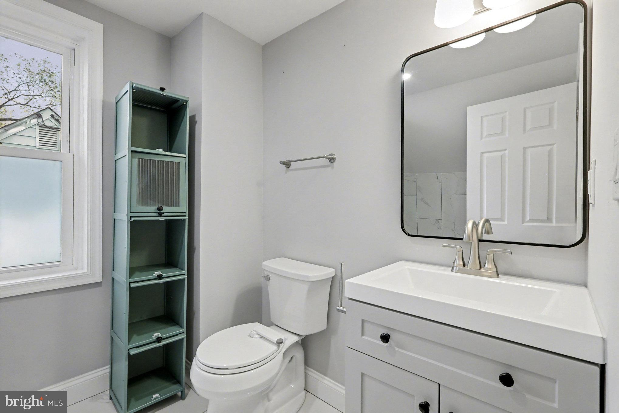 5406 Taylor Road Hyattsville, MD 20781 - Photo 15 of 26 a bathroom with a toilet a sink and mirror