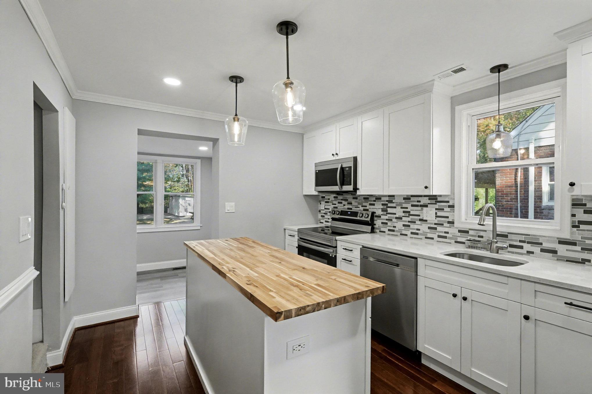 5406 Taylor Road Hyattsville, MD 20781 - Photo 8 of 26 a kitchen that has a lot of cabinets in it and wooden floors