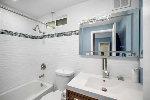 a bathroom with a sink mirror vanity and toilet