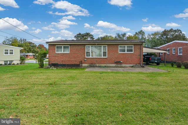 a view of a yard in front of a house with large tree