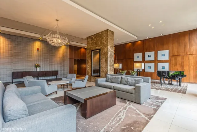 a living room with furniture a chandelier and a dining table