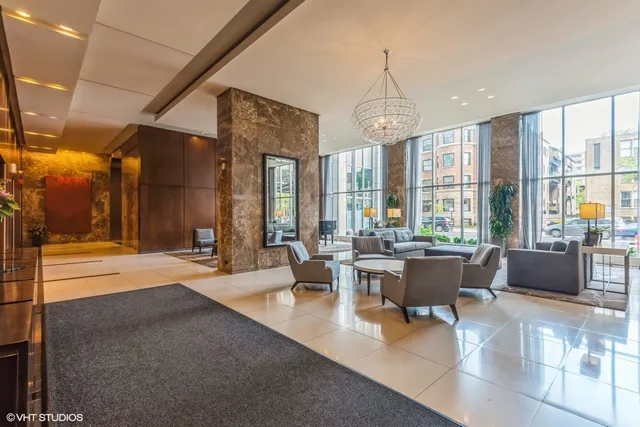 a living room with furniture a large window and chandelier