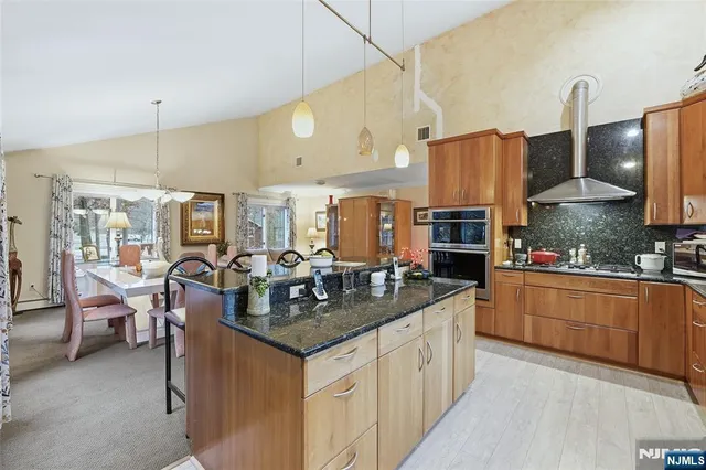 a kitchen with stainless steel appliances granite countertop a sink a stove and a refrigerator