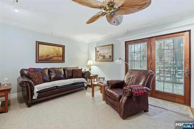 a living room with furniture a large window and a chandelier