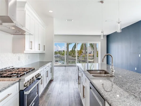 a kitchen with a stove a sink and a wooden cabinets