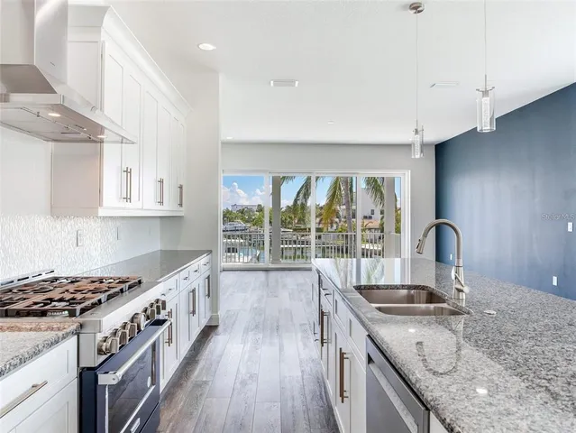a kitchen with a stove a sink and a wooden cabinets