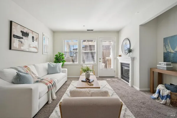 a living room with furniture white walls and a fireplace