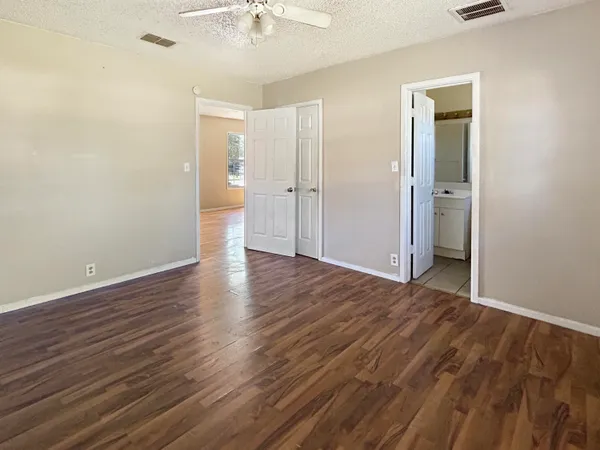 a view of an empty room with wooden floor