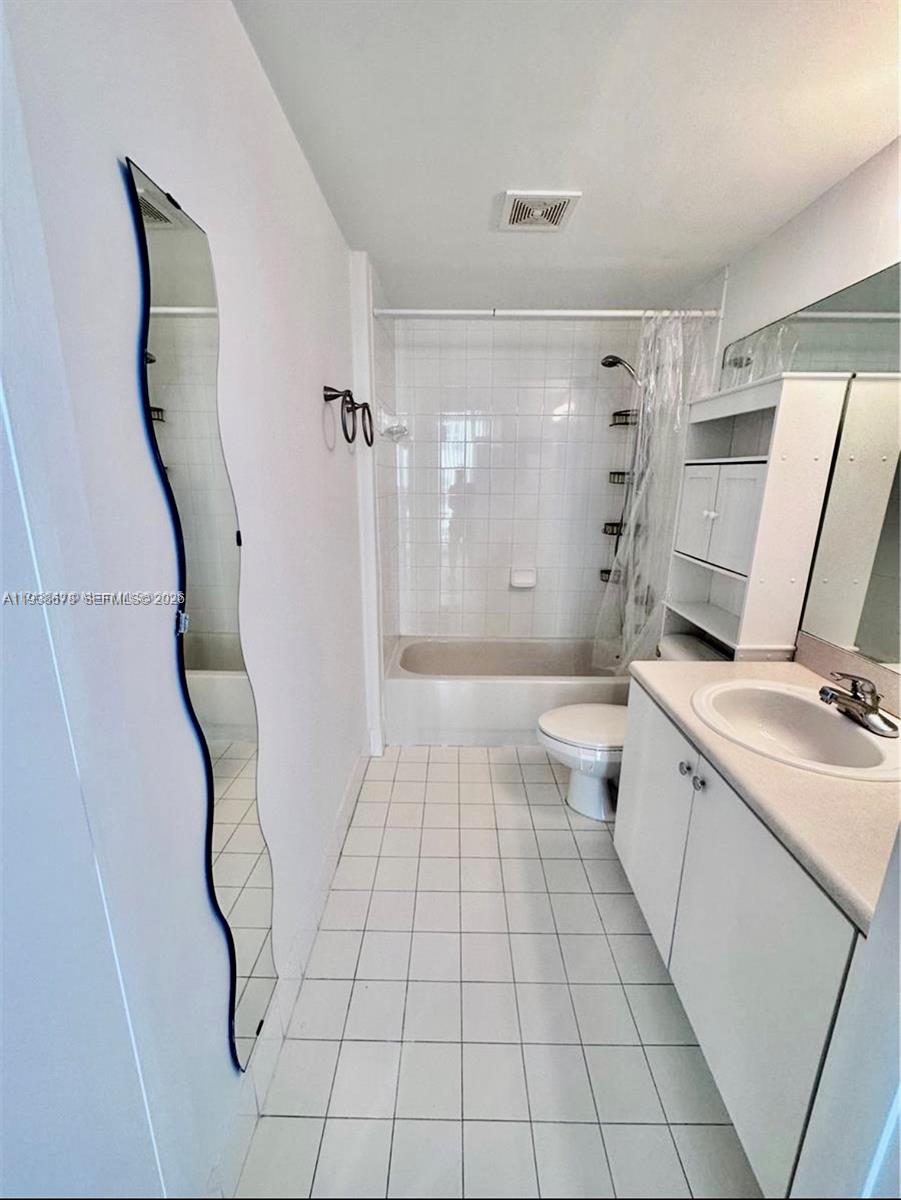 5091 Northwest 7th Street, Unit 1015 Miami, FL 33126 - Photo 8 of 30 a bathroom with a sink a toilet and shower
