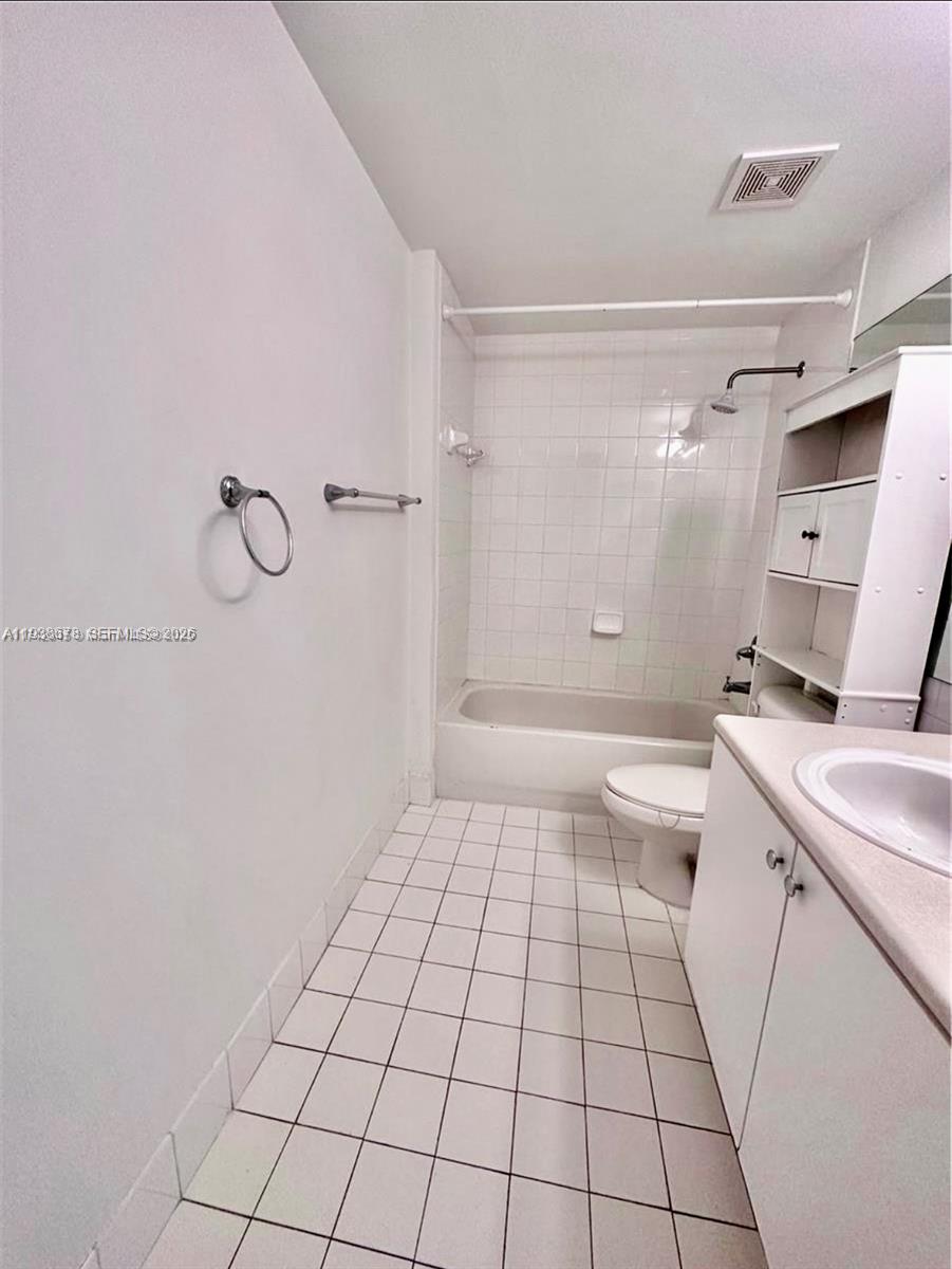 5091 Northwest 7th Street, Unit 1015 Miami, FL 33126 - Photo 10 of 30 a bathroom with a sink a toilet and shower