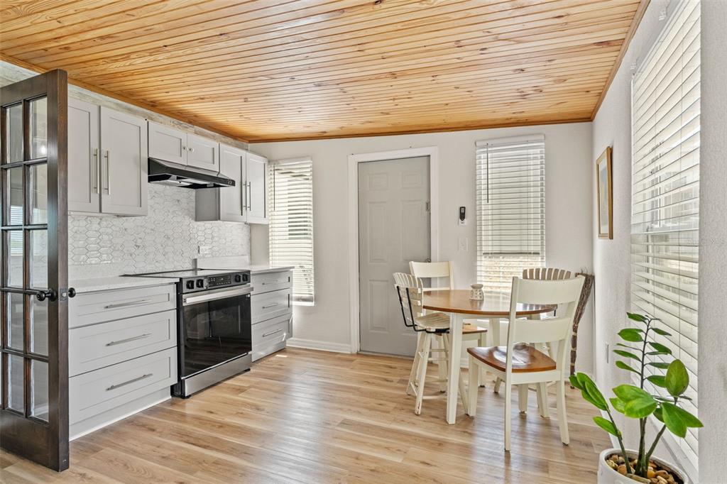 11487 Linden Drive Spring Hill, FL 34608 - Photo 17 of 42 a kitchen with granite countertop furniture a dining table wooden floor and stainless steel appliances