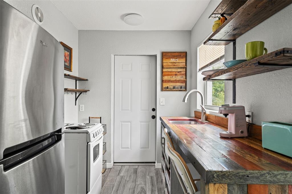 11487 Linden Drive Spring Hill, FL 34608 - Photo 29 of 42 a kitchen with stainless steel appliances granite countertop a refrigerator a stove and a sink with wooden floor