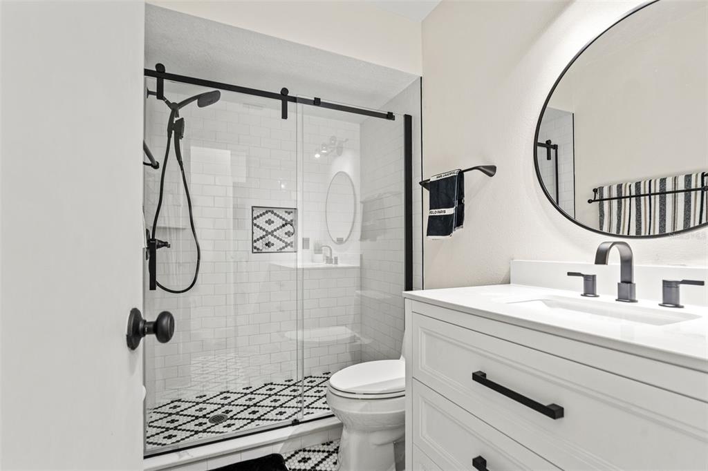 11487 Linden Drive Spring Hill, FL 34608 - Photo 4 of 42 a bathroom with a granite countertop sink toilet mirror and shower