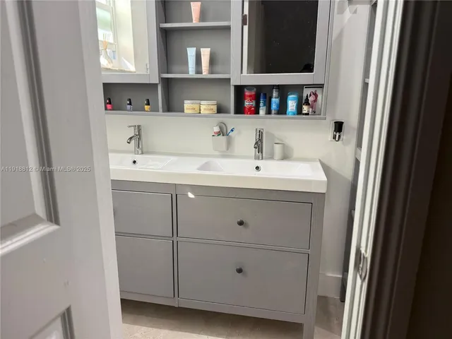 a view of cabinets a sink and a window in a laundry room