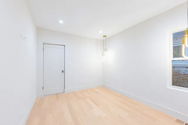a view of an empty room with wooden floor and entryway