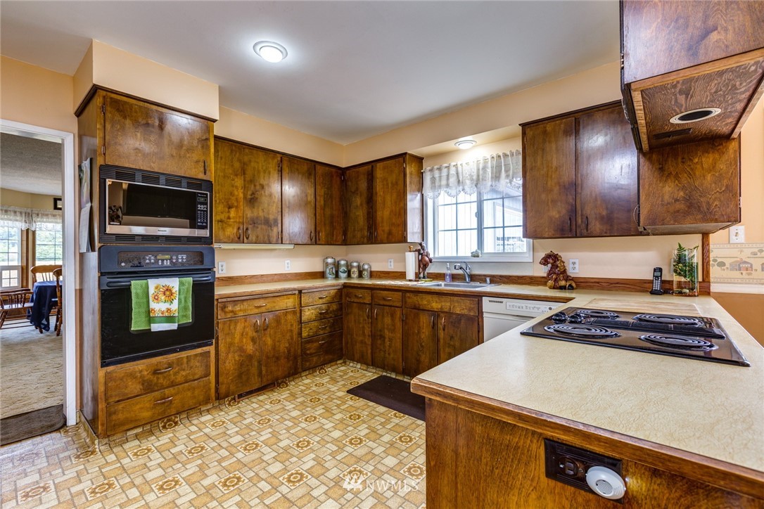 401 West Pole Road Lynden, WA 98264 - Photo 10 of 40 a kitchen with stainless steel appliances granite countertop a stove a sink and a microwave