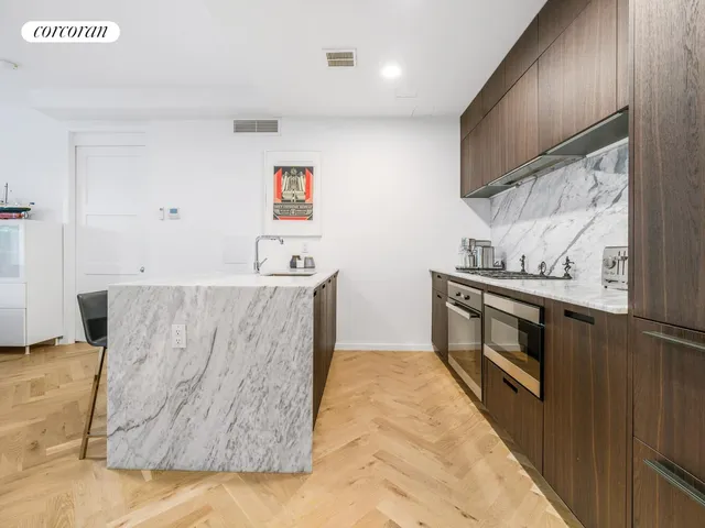 a living room with stainless steel appliances kitchen island granite countertop furniture and a flat screen tv