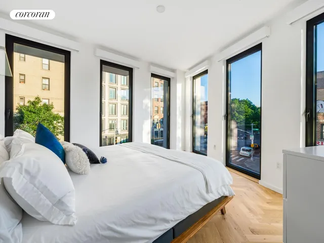 a bedroom with large bed and large windows
