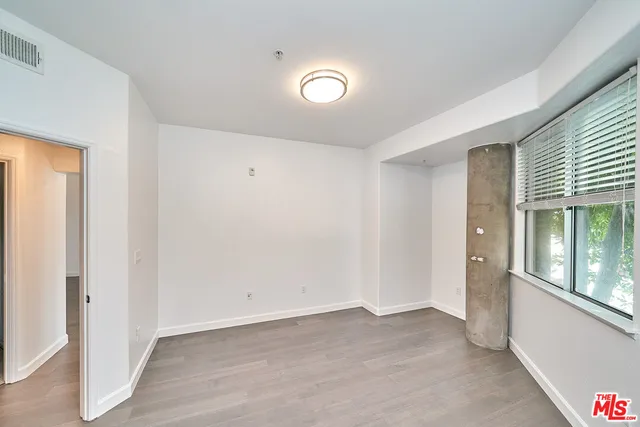 a view of an empty room with glass door and windows